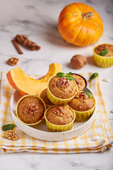 Muffins with pumpkin, walnuts and cinnamon. Delicious homemade dessert. Halloween treats. Vegetarian dish.