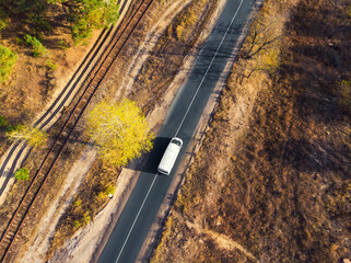 Aerial top view white modern delivery small shipment cargo courier van moving fast on motorway road city urban suburb. Busines distribution and logistics express service. Mini bus driving highway day © Kirill Gorlov