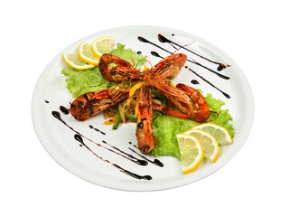 Spicy shrimps with lemon and lettuce on white round plate isolated