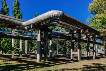 Steel pipelines outgoing from the plant at sunny day