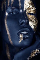 fashion portrait of a blue-skinned girl with gold make-up. Beauty face.