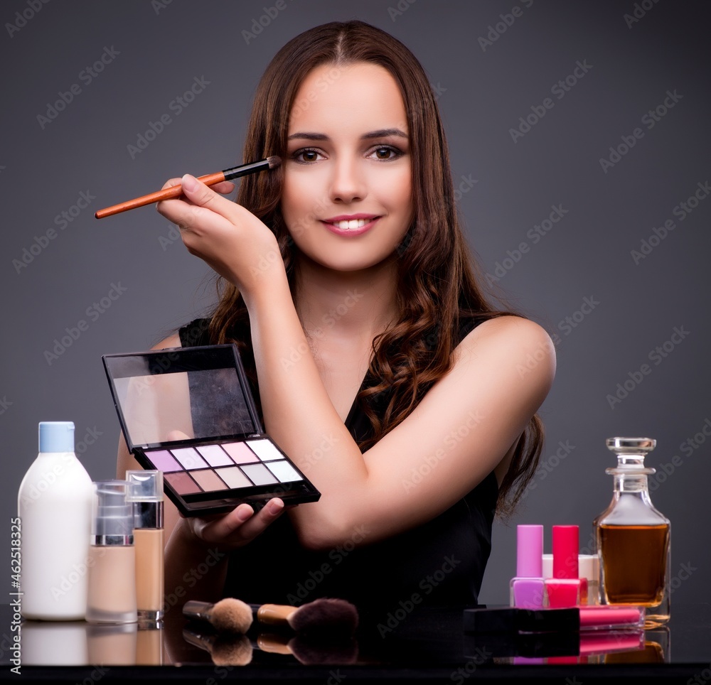 Wall mural beautiful woman applying make-up in fashion concept