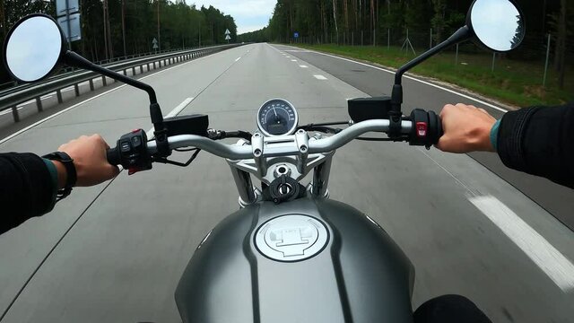 First person view of driving on a motorbike at the highway through the forest. POV shot of riding on a scrambler motorbike. Cafe racer driving at the highway. High quality 4k footage