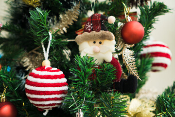 Christmas tree assembled with ornaments. Red, silver and gold balls, gift boxes, lights, Santa Claus and others. Selective focus.