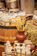 Farm life style, bottles with fresh milk, cereal ears in clay jug, organic products, healthy food