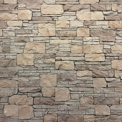 An ancient stone wall of gray-brown color. An old stone wall with a brick texture. Gray background.