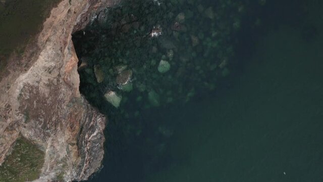 Aerial view of Ocean water crashing along the coastline at Zennor Cove, Saint Ives, Cornwall, United Kingdom.