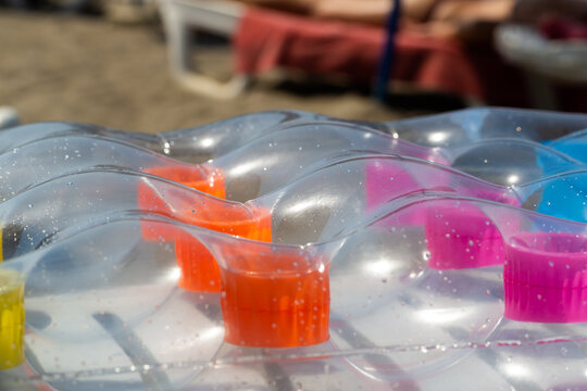 Inflatable Mattress Close-up. Transparent Mattress In A Pool. Pink And Orange Rubber Lilo