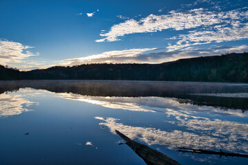 美しい紅葉の白駒池の湖面に反射する日の出