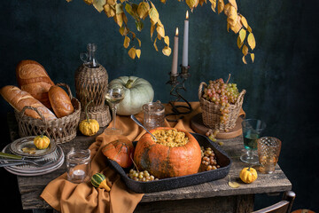 Autumn flat lay composition, with copy space on wooden background. Variety of edible and decorative gourds and pumpkins, rosehips, walnuts, cones, apples, kaki fruit, chestnuts and corn on the cob.