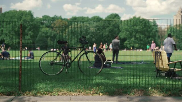 Bike parked in the Central park, New York, USA. Recreation, enjoyment, leisure pursuit and vacation concept. People enjoying weekend in a park on fresh green lawn.