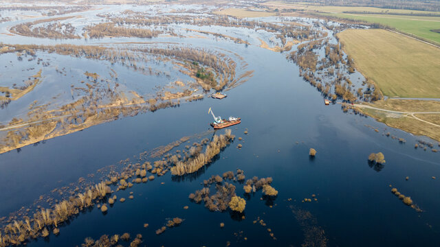 Aerial view of dredge replenish sand in river. Canal is being dredged by excavator. Top view of dredging boat crane.