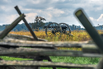 Civil War cannon in field with blurred fence in front - obrazy, fototapety, plakaty