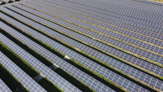 Aerial video from a height close up of solar panels at a solar power plant. Solar farm that produces clean energy, green tariff