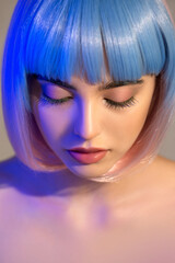 Beautiful young woman wit closed eyes and clean perfect skin in neon studio light. Selective focus.