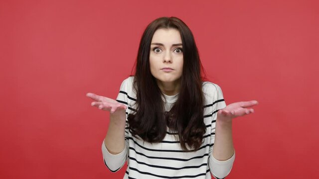 Portrait of woman asking who why make this conflict, looking with annoyed indignant expression, wearing casual style long sleeve shirt. Indoor studio shot isolated on red background.