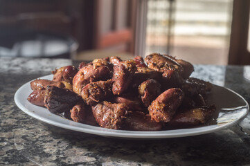 Chicken heart on a white plate with dark background , copy space and selective focus