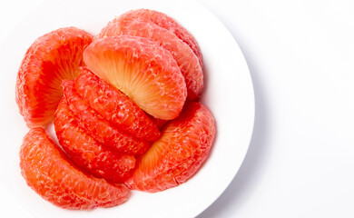 Red pomelo or Ruby Siam in Thai Brightly colored sweet fruit grown in Asia. on a white plate isolated on a white background empty space for text