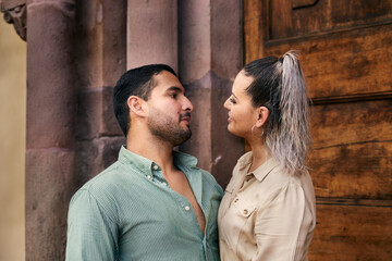 Young latin male and female couple looking at each other in love between 25 and 35 years old