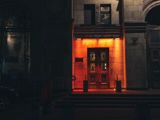 An old door with red-orange illumination in one of the high-rise buildings in Moscow