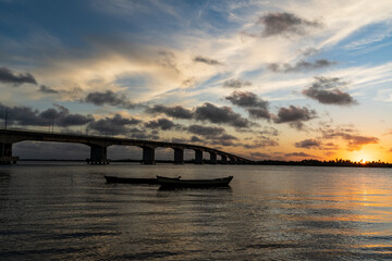 Obraz premium Sunset in the river with boats and bridge