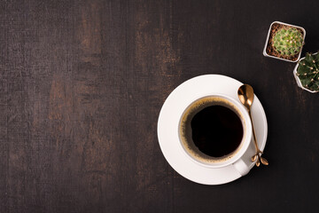 coffee cup with cactus on the wooden background with copy space, top view
