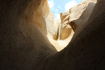 the view from the dark sandy cave up to the exit to the blue sky