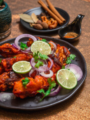 Fototapeta na wymiar Tandoori chicken on the black plate.