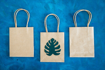 environmental awareness and consumer behaviour concept, Sustainable paper shopping bag with tropical green paper leaves