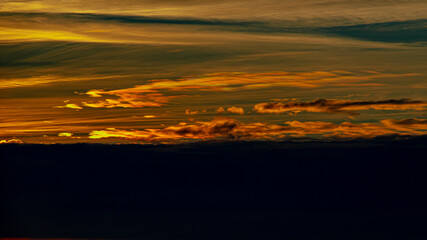 Dramatically saturated with bright colors sunset over black clouds