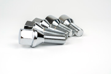 shiny metal bolts fastening a car wheel close-up on a white background. car spare part