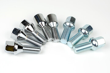 shiny metal bolts fastening a car wheel close-up on a white background. car spare part