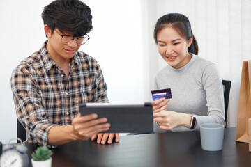 Shopping online concept a lovely couple adding credit card information to use in online financial transaction