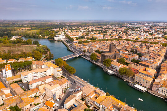 Bird's eye view of Agde, southern France. Residential buildings and Herault River visible from above.