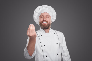 Cheerful chef showing Italian gesture on gray background