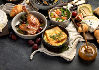French food assortment on dark background.