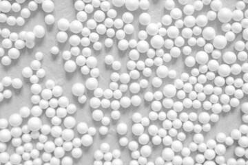 White round spheres of different sizes on a gray background top view. Minimalistic abstract background with geometric shapes.