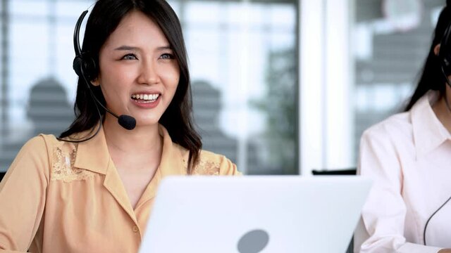 close up face of smiling woman call center working on station of computer. Happy staff for customer support. People talking on headphone microphone in feeling happy.