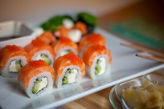 Salmon sushi set. Sushi roll Philadelphia with red fish, salmon, red caviar. Roll with soft avocado and cream cheese under a layer of massago caviar. Classic sushi. Food background.