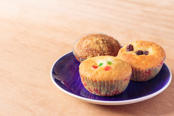 Banana cupcakes in blue plate on wooden background