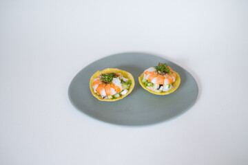 Asian style shrimp tartlets on white plate on white background. Close up, photo for the menu, tartlets with prawns, isolated on white