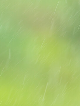 Rain pours on a green nature background.