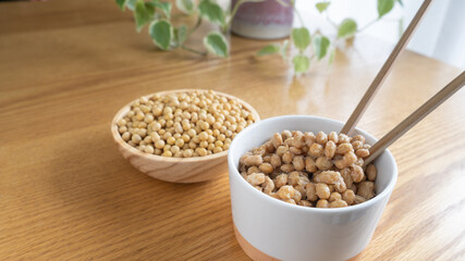 日本の納豆と生大豆。納豆を箸で混ぜる。