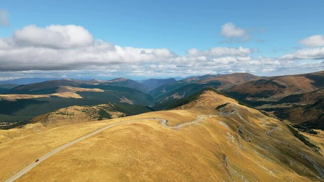 Aerial drone view of nature in Romania. Carpathian mountains, sparse vegetation, Transalpina road with cars