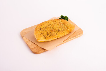 Homemade garlic bread on the wooden plate.