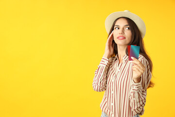 Attractive girl holds credit cards on yellow background