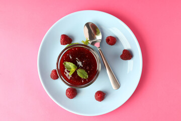 Concept of tasty food with raspberry jam on pink background