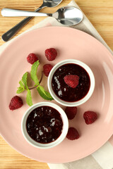Concept of tasty food with raspberry jam on wooden background