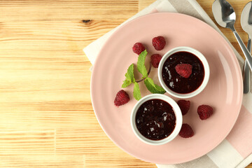 Concept of tasty food with raspberry jam on wooden background