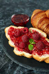 Concept of delicious food with croissants with raspberry jam on black smokey background